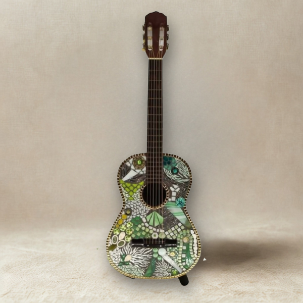 Guitare décorative avec motif vert, mosaïque et détails blancs et noirs