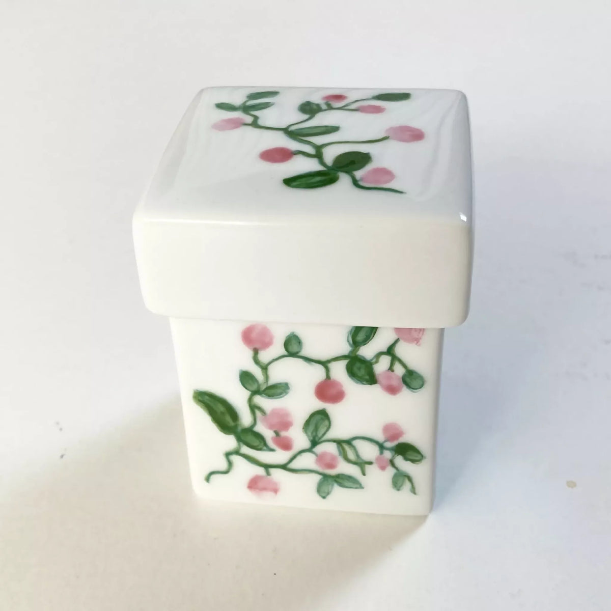 Boîte à bijoux en porcelaine blanche, couvercle rectangulaire floral rose et vert.