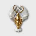 Porte-couvert homard blanc et doré, forme de pinces et queue décoratives.