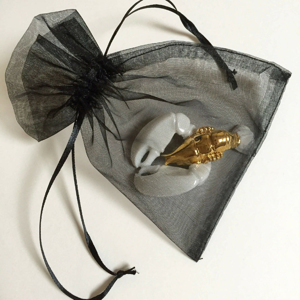 Porte-couvert homard doré dans sachet organza noir à nœud.