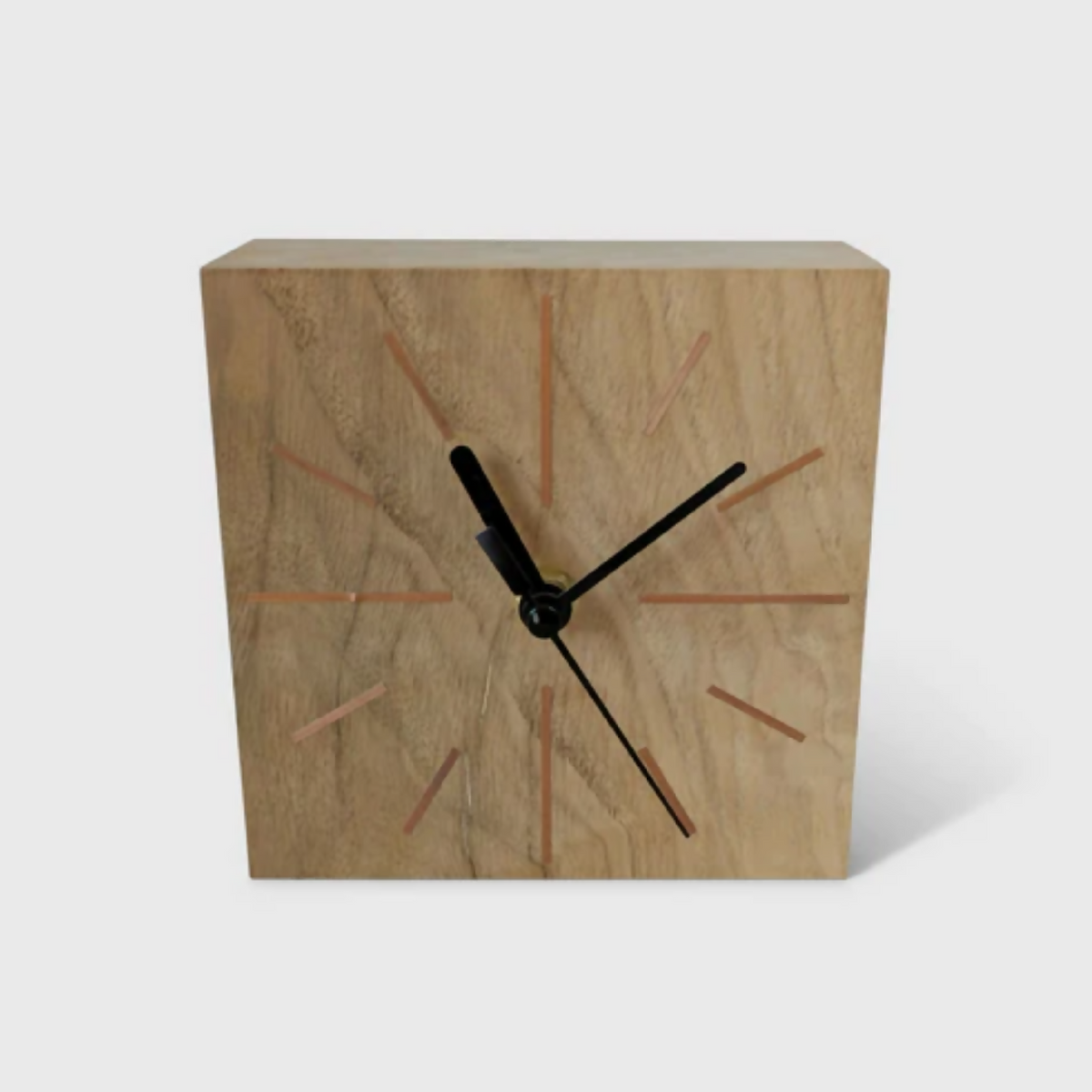 Horloge de bureau carrée en chêne clair, aiguilles noires et repères colorés sur le cadran.