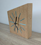 Horloge de bureau en bois avec repères bleus, aiguilles noires et bouton doré
