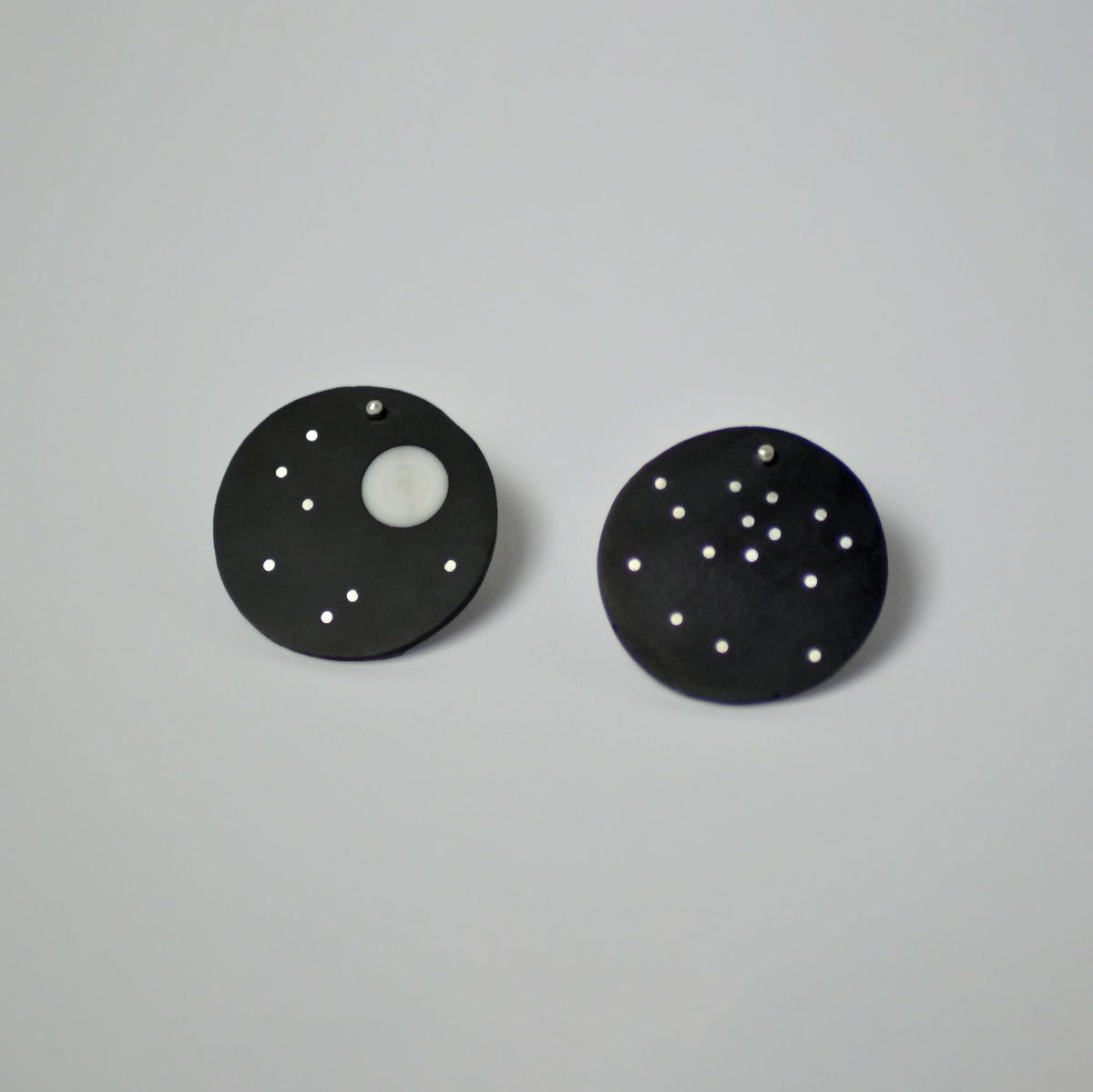 Paire de boucles d’oreilles constellation rondes noires, motifs d’étoiles blanches