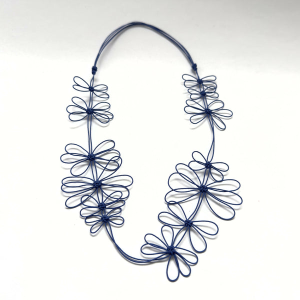 Collier de fleurs de prunier bleu en fil, fleurs enchevêtrées sur cordon souple.