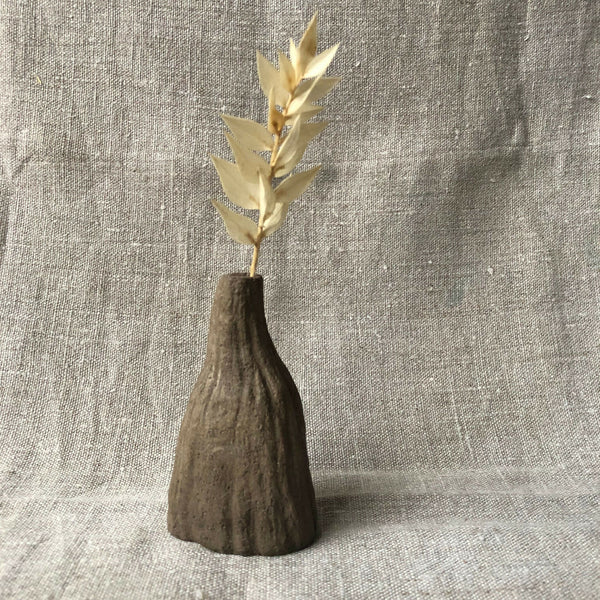 Mini vase rainuré en terre sombre avec tiges d’herbes sèches beiges
