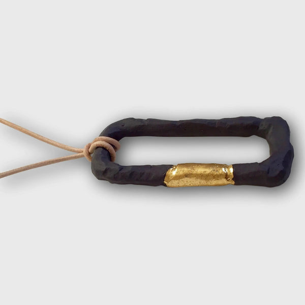 Collier en porcelaine noire, maillons annelés et élément central doré, cordon noué