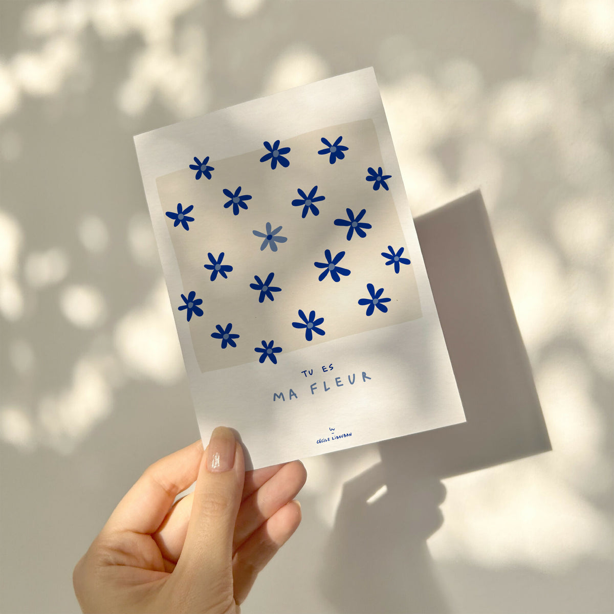 Carte de vœux blanche à motifs fleurs bleues, tenue en main, « Tu es ma fleur »