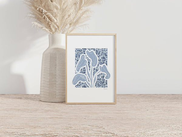 Tirage A4 encadré avec cadre bois clair, illustration d’alocasia bleue sur fond clair.