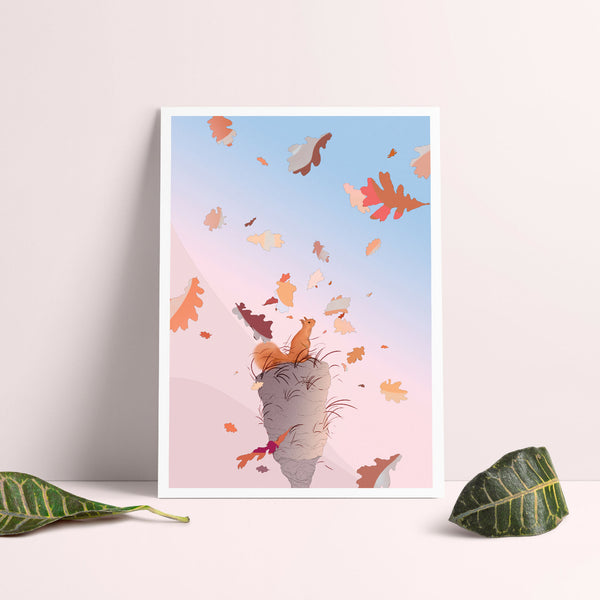 Affiche encadrée d’un chat gris sautant parmi des feuilles aux tons orange et bleu.