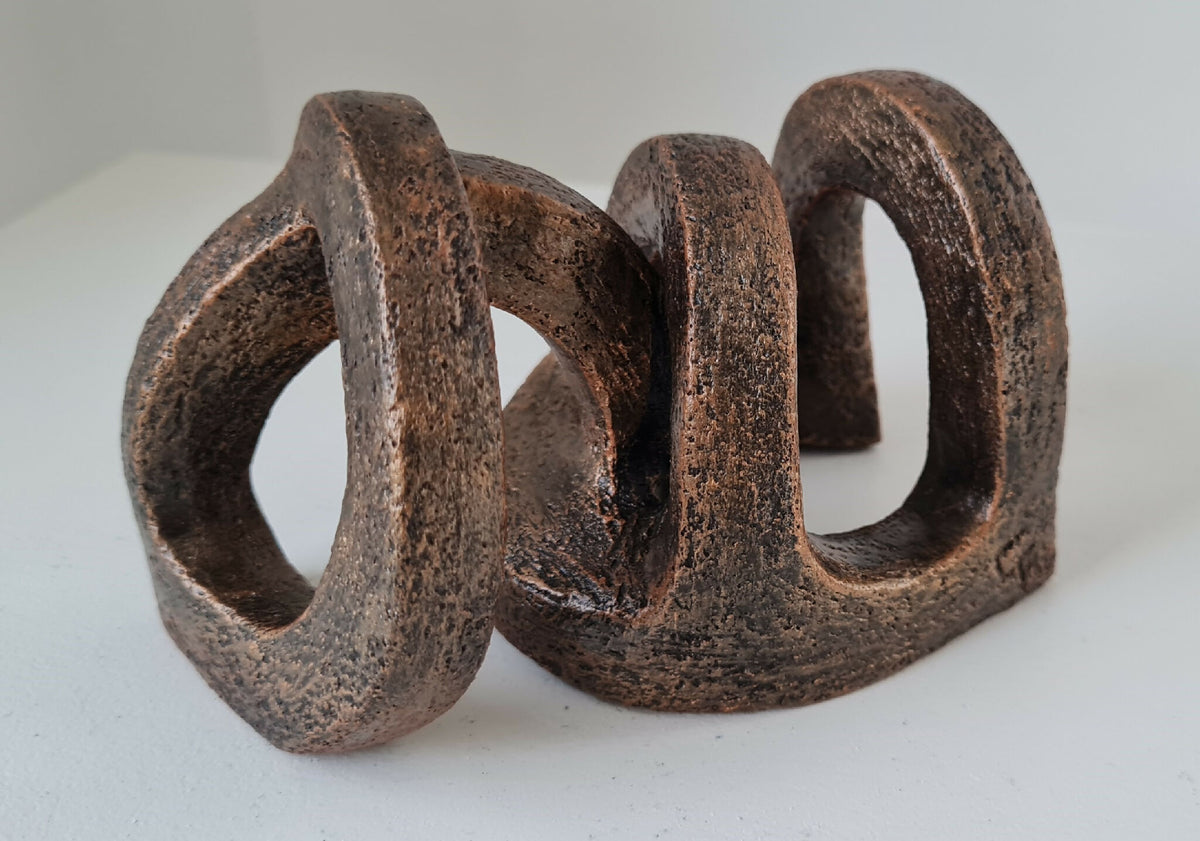 Sculpture abstraite en bois brun foncé, trois arches ajourées, effet texturé
