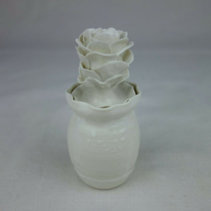 Vase en céramique blanc, fleurs en relief sur le dessus, vue arrière légèrement.