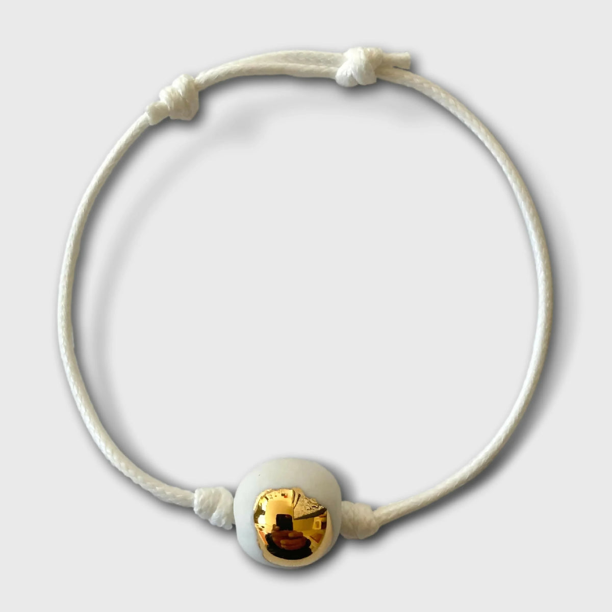 Bracelet cordon blanc avec goutte dorée brillante en porcelaine