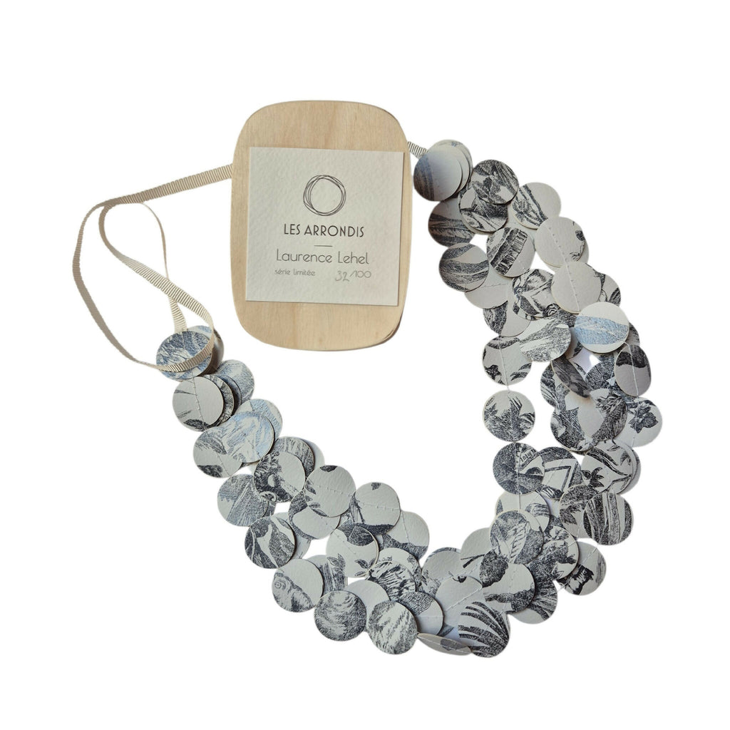 Collier en disques ronds noir et blanc à motifs, avec étiquette et ruban