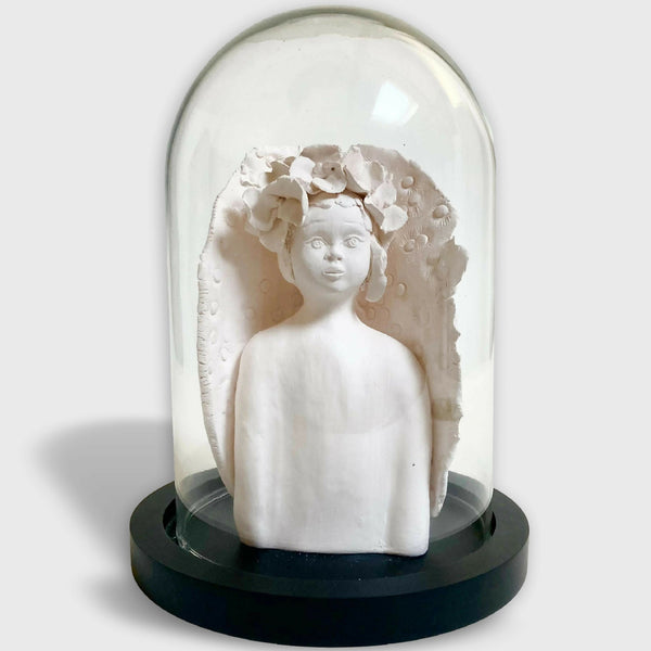 Sculpture d'enfant blanche avec fleurs en relief, sur base noire.