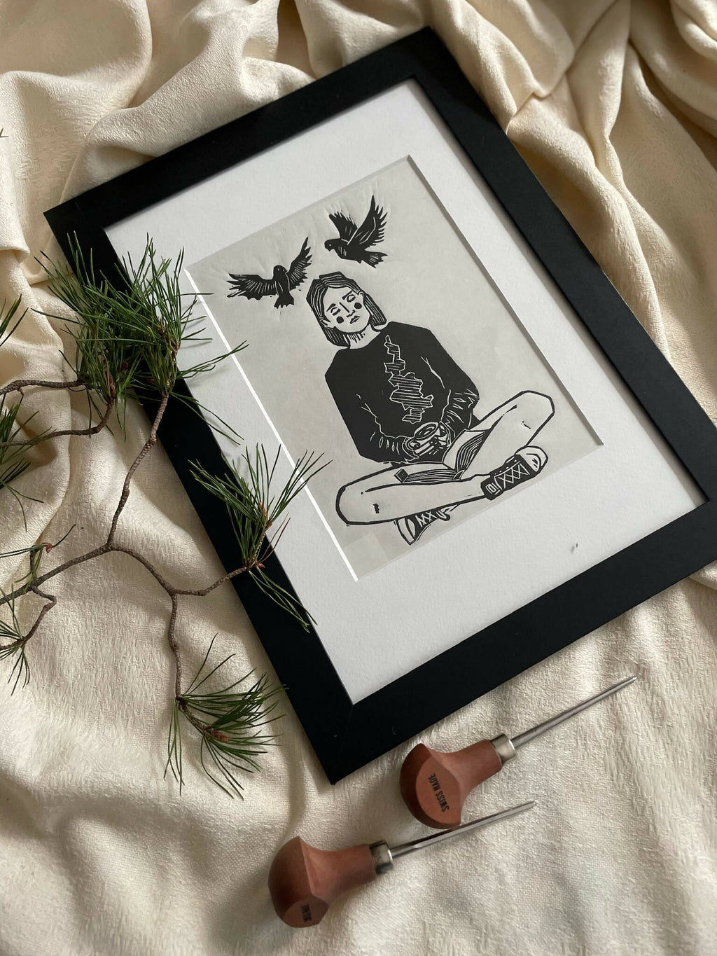 Illustration encadrée à bord noir : femme méditant avec livre, oiseaux stylisés au-dessus.