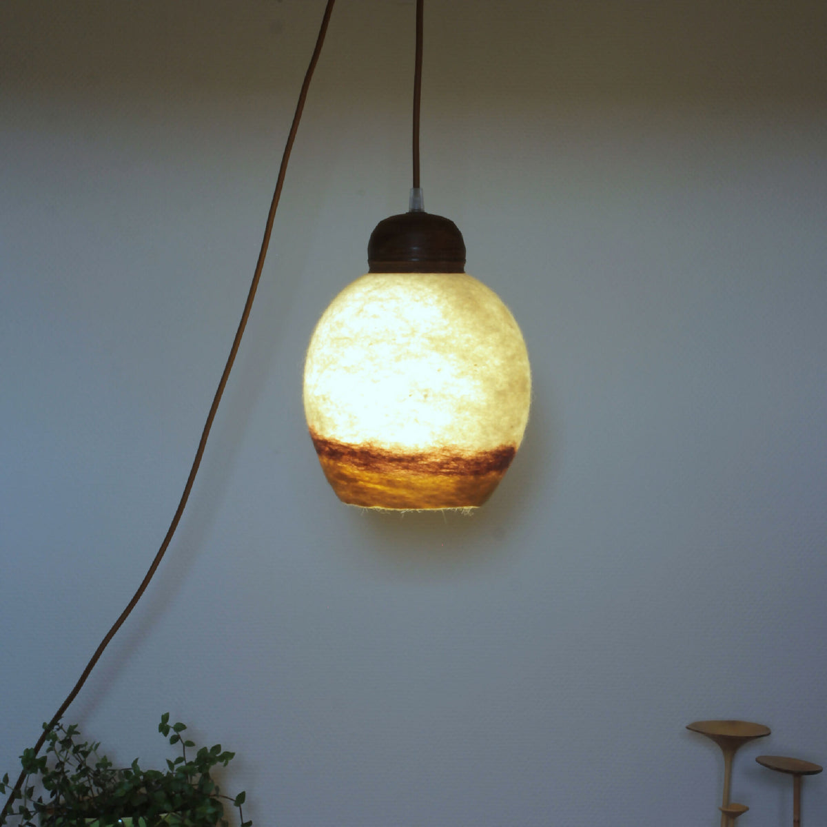 Lampe baladeuse TERRE DE SIENNE abat-jour en verre ambré avec base en bois sombre.