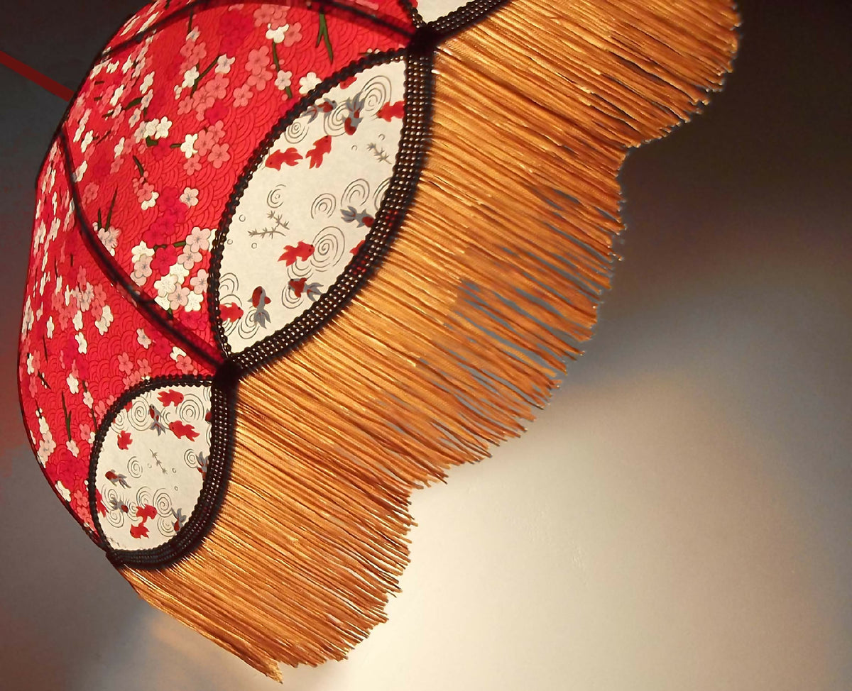 Abat-jour en papier japonais rouge, franges dorées et liseré noir contrasté