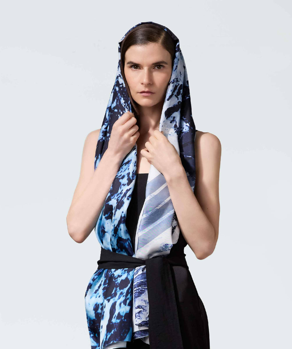 Écharpe légère bleue et noire motif abstrait, portée autour du cou et de la tête