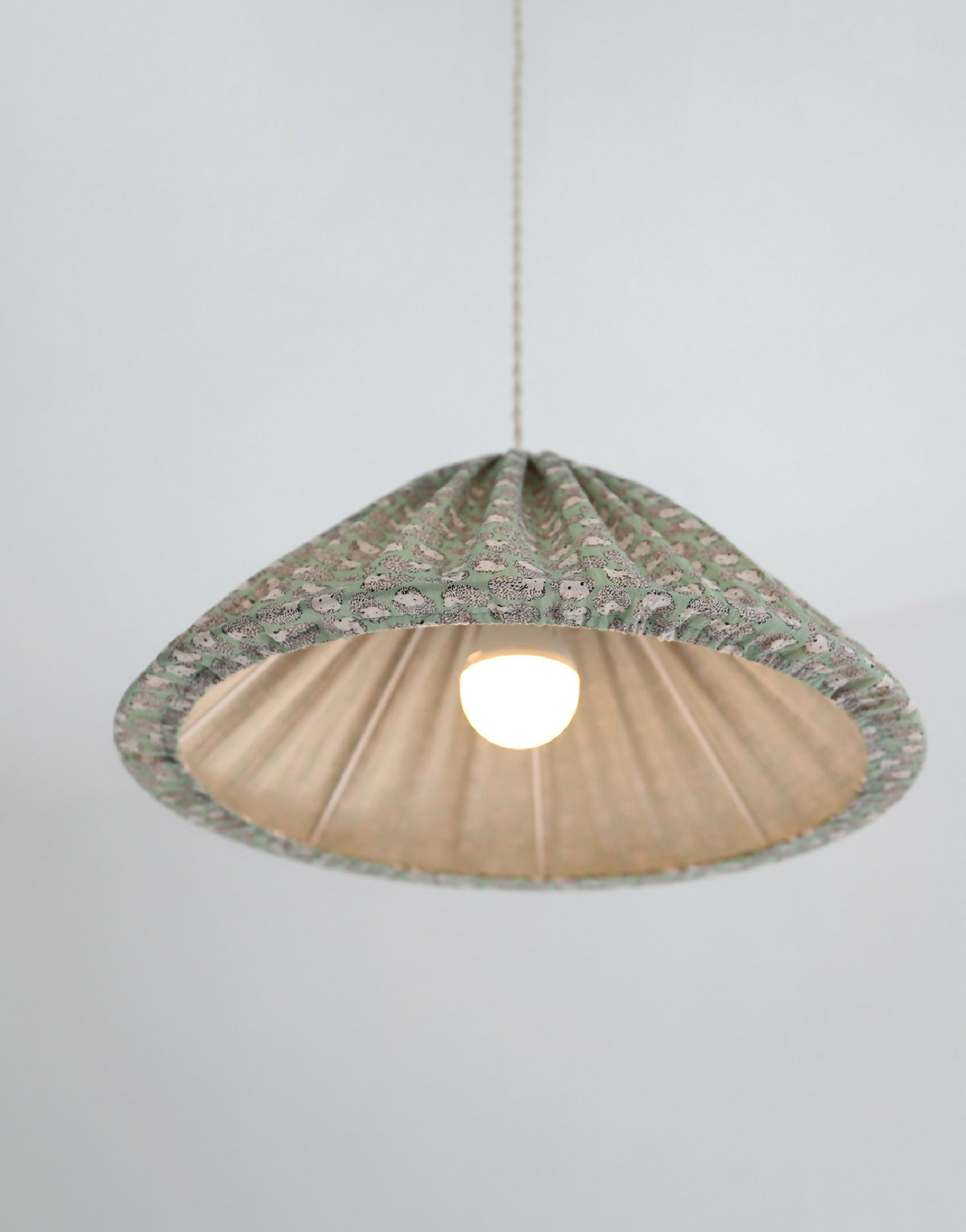 Suspension conique vert à motif hérissons, vue de dessous avec lumière allumée