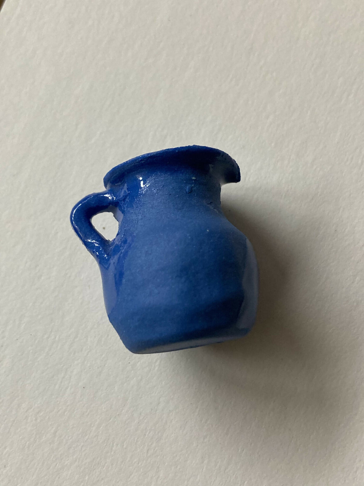 Pendentif miniature en porcelaine bleue en forme de pichet, vue rapprochée de l’anse