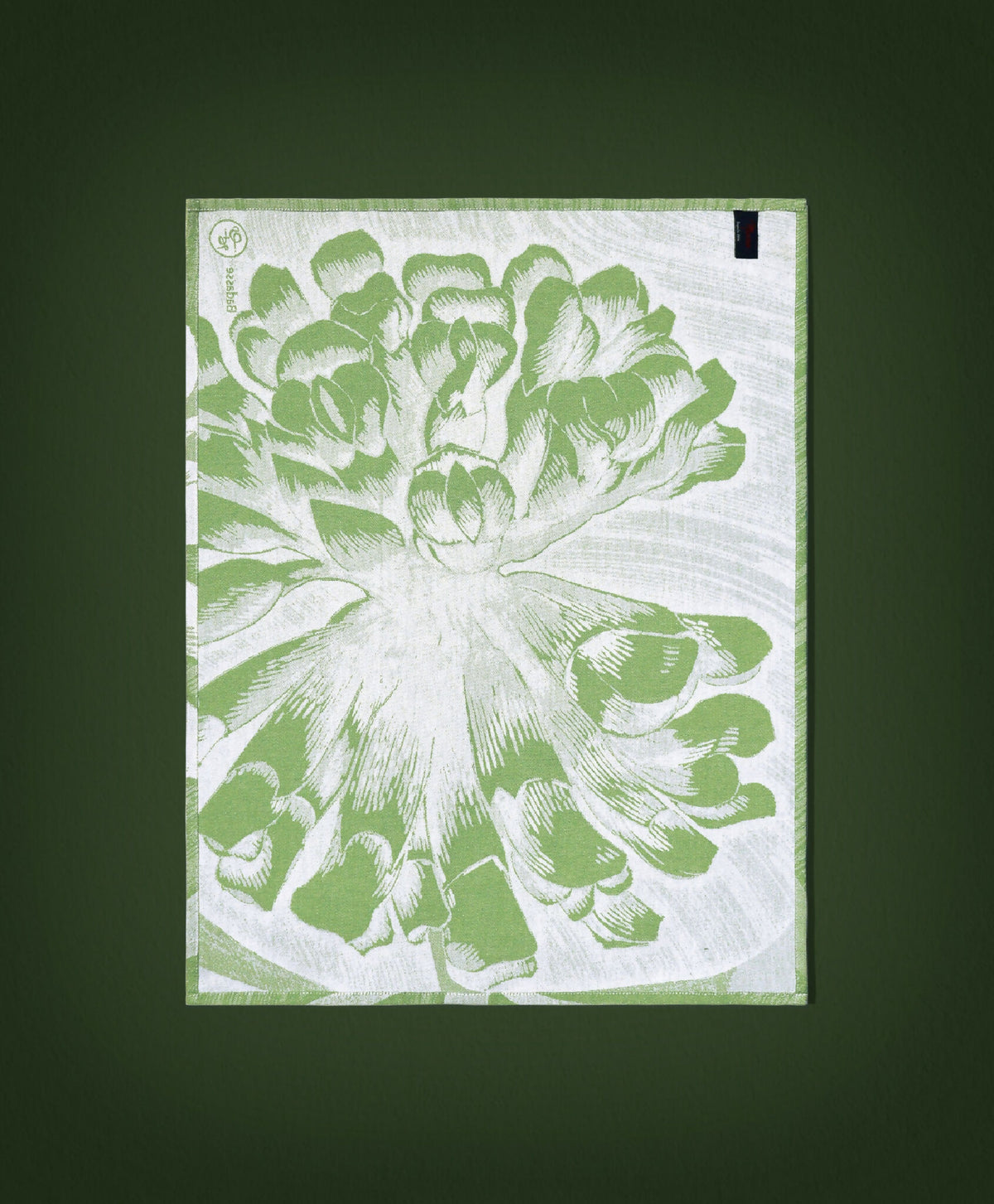 Torchon vert à motif floral blanc, bord ourlé et étiquette noire