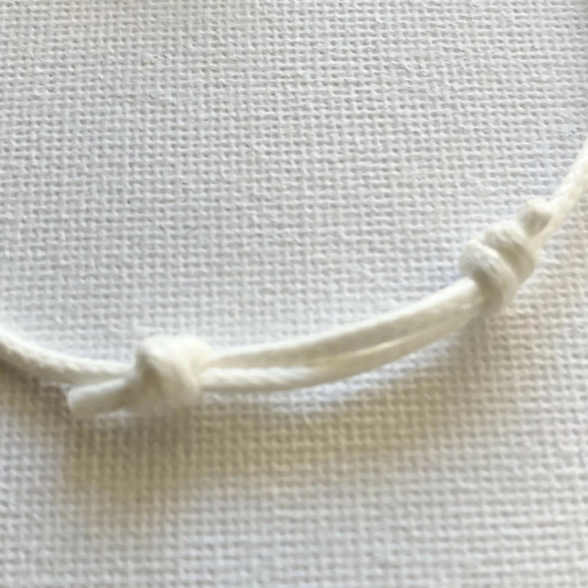 Détail bracelet : cordon blanc torsadé et nœuds en porcelaine blanche