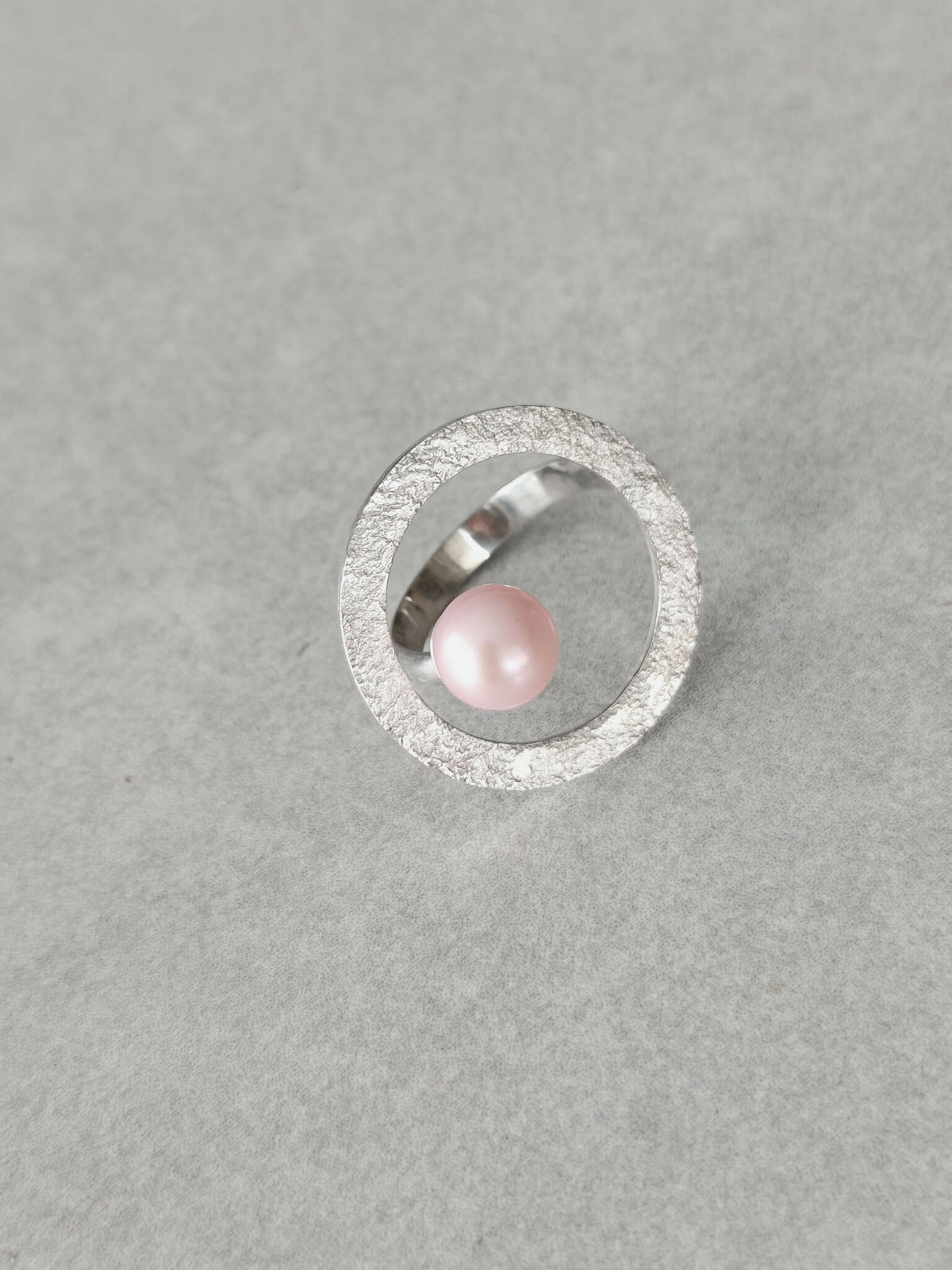 Bague Atoll perle rose nacrée dans un cercle texturé argenté, vue de dessus