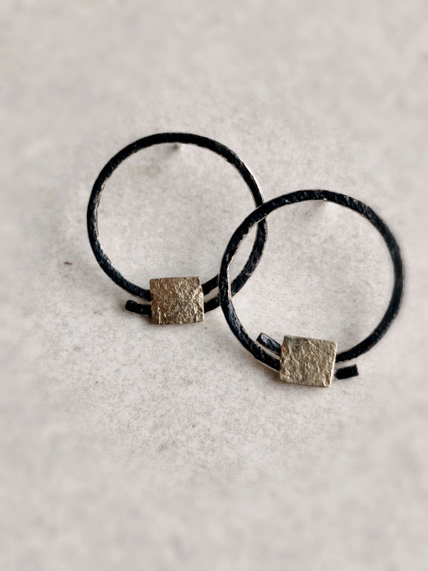 Boucles d’oreilles anneaux noirs, carrés texturés dorés à la base