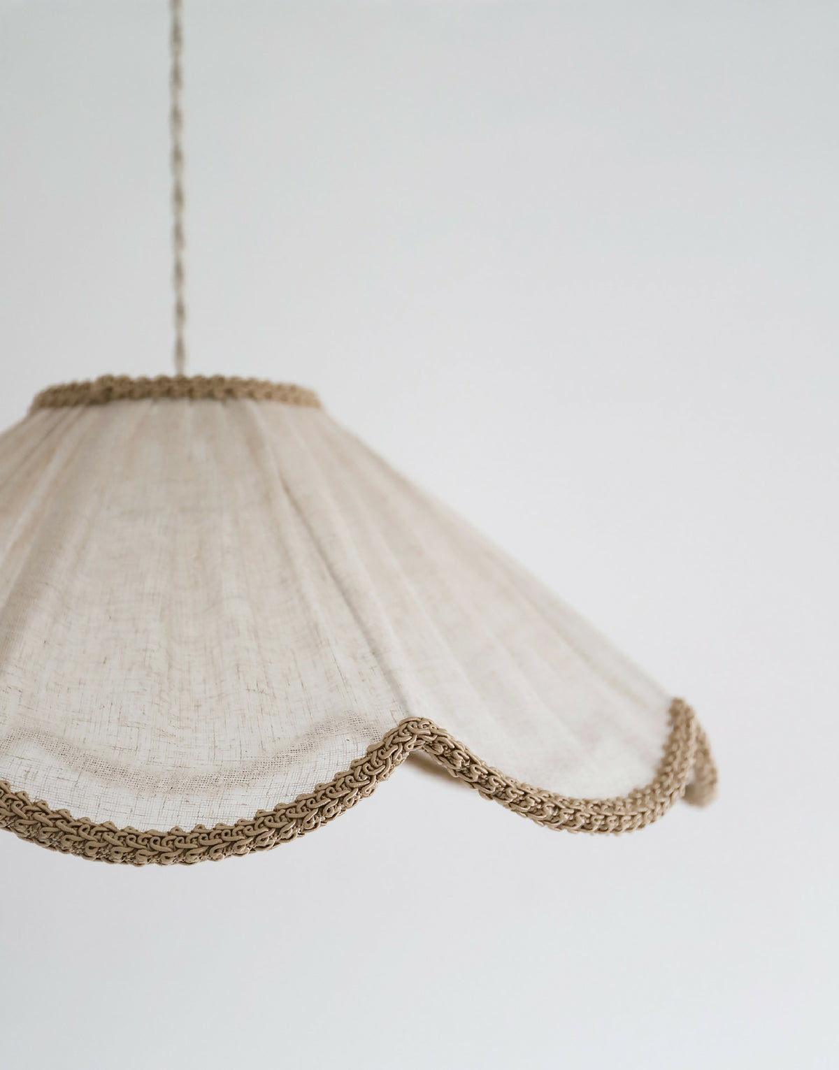 Suspension beige : vue latérale de l’abat-jour en tissu et bord tressé ondulé