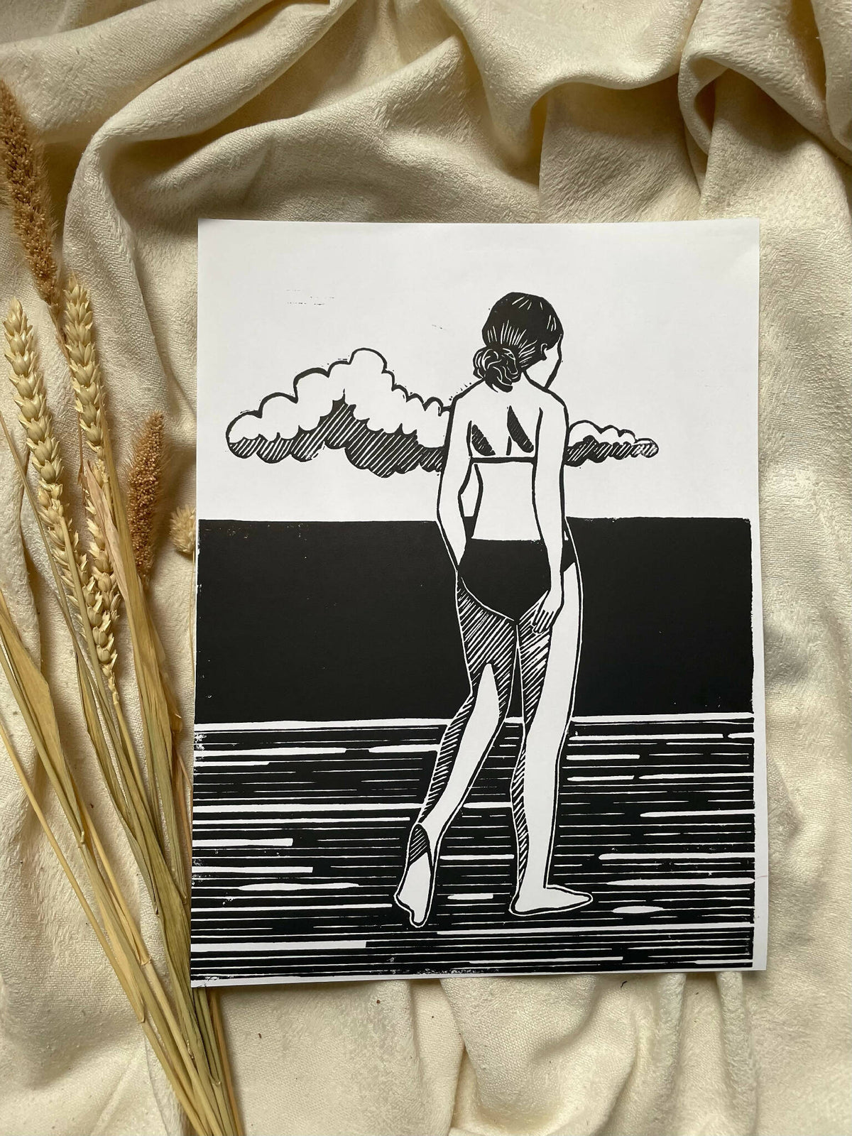 Affiche encadrée, illustration noir et blanc d’une femme jouant de la guitare sous des nuages.