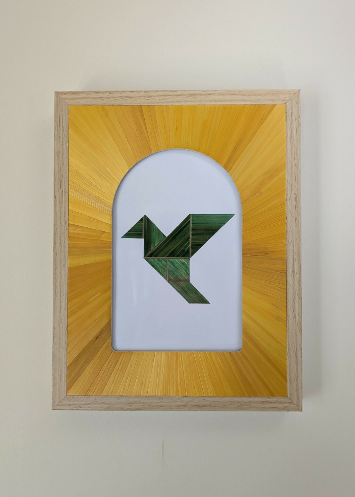Tableau encadré en bois clair, motif géométrique vert sur fond blanc et jaune