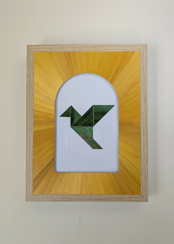 Tableau encadré en bois clair, motif géométrique vert sur fond blanc et jaune