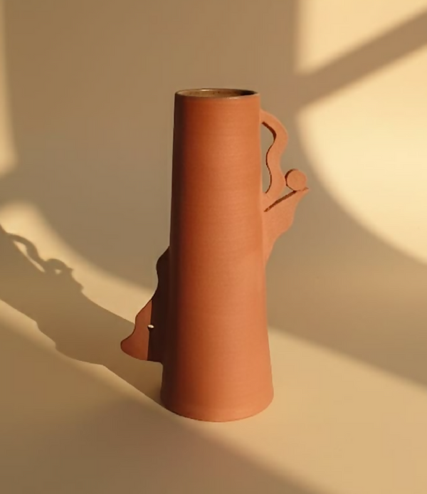 Vase en céramique orange avec motif découpé, silhouette ondulée sur le côté