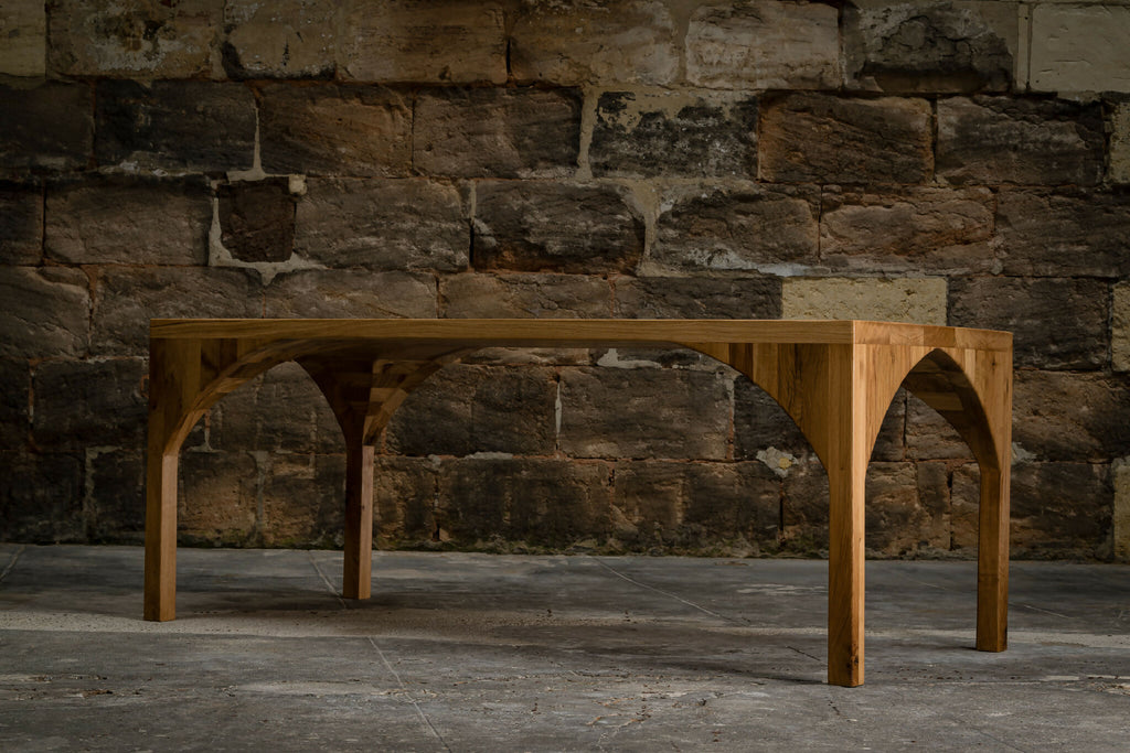 Table en bois avec piètement en arc et plateau rectangulaire.