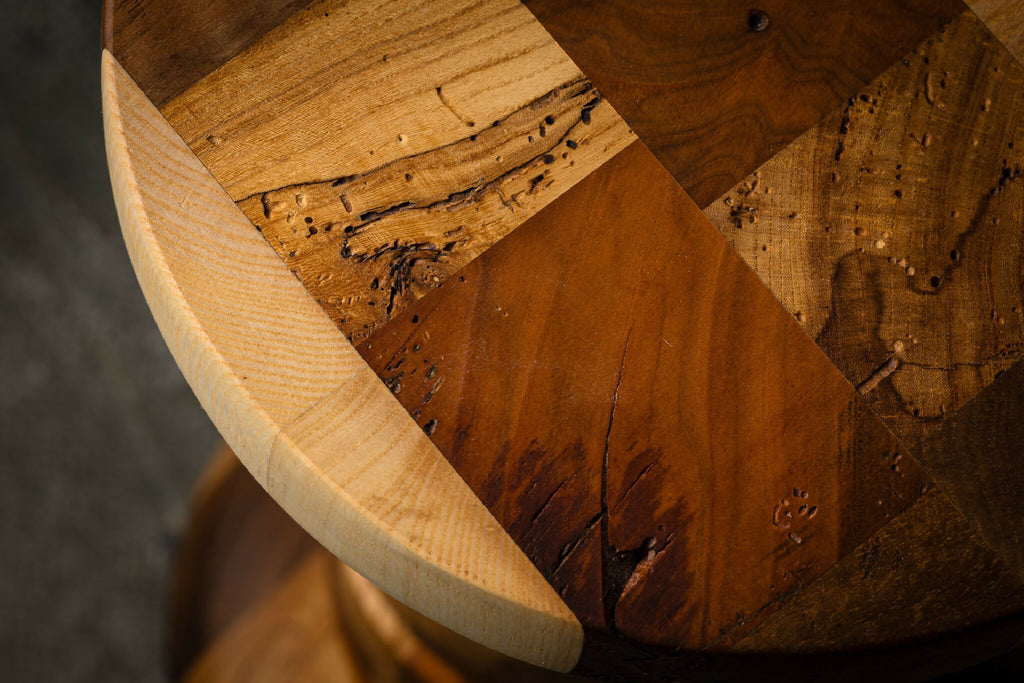 Dessus rond d’une table d’appoint en bois sculpté, bord clair et motifs