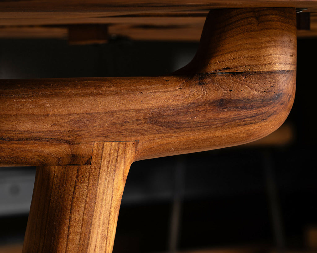 Table en bois massif, détail d’un renfort arrondi au veinage riche.