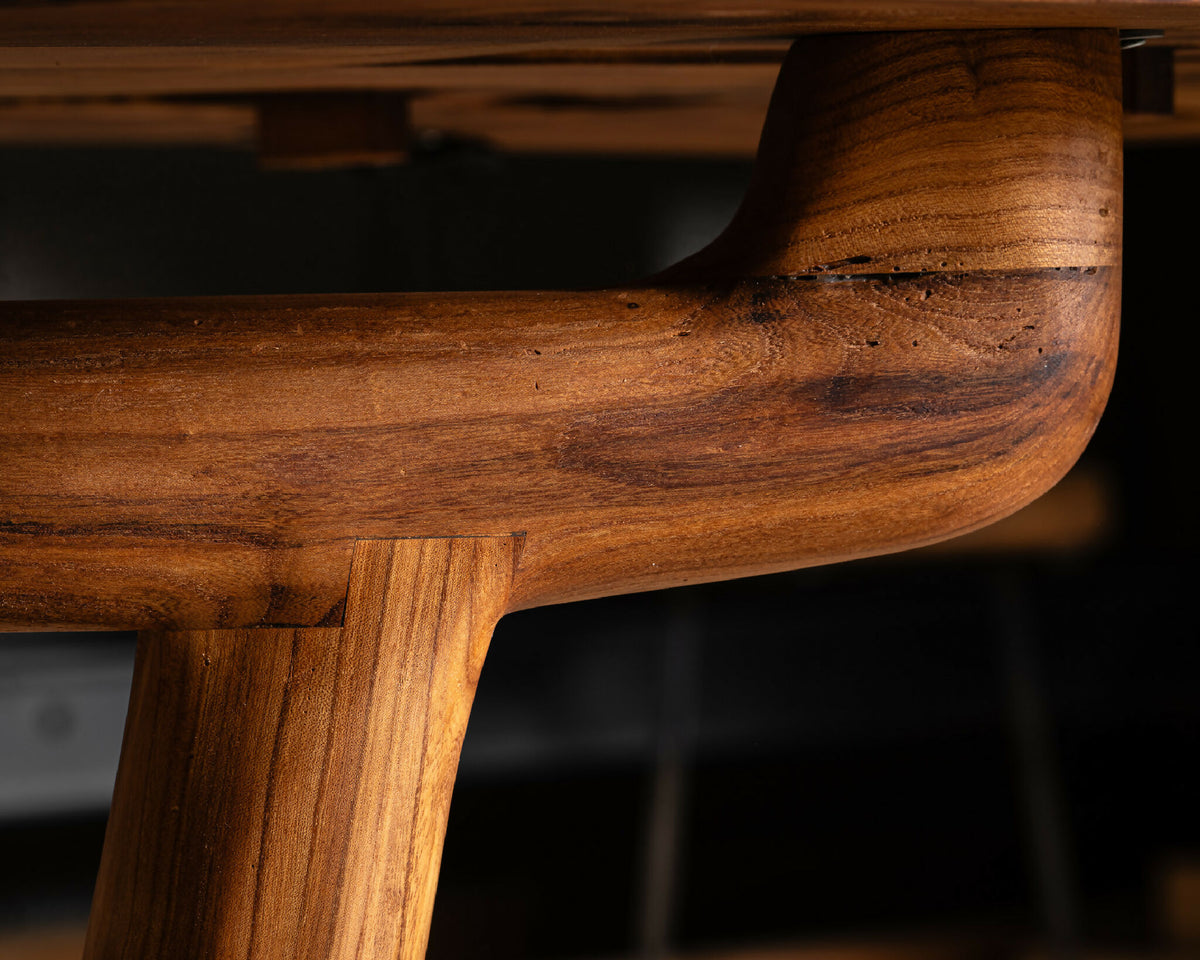 Table en bois massif, détail d’un renfort arrondi au veinage riche.