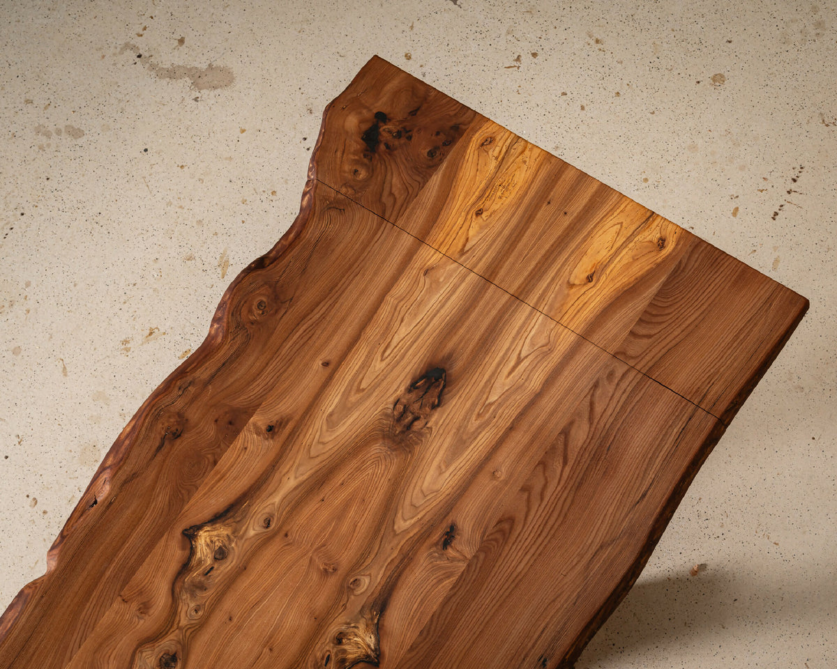 Table en bois massif, plateau rectangulaire avec nœuds et reflets du veinage.