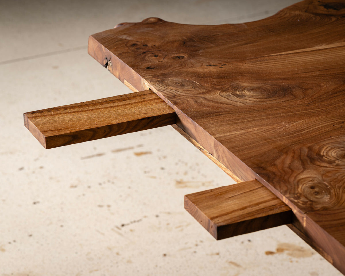 Table en bois massif, vue dessous du piètement avec ouvertures et traverses.