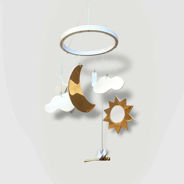 Mobile de naissance : lune dorée, nuages blancs et étoile dorée suspendus.