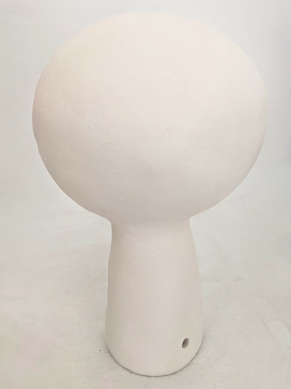 Lampe à poser design blanche, vue de face, petit trou en bas du socle