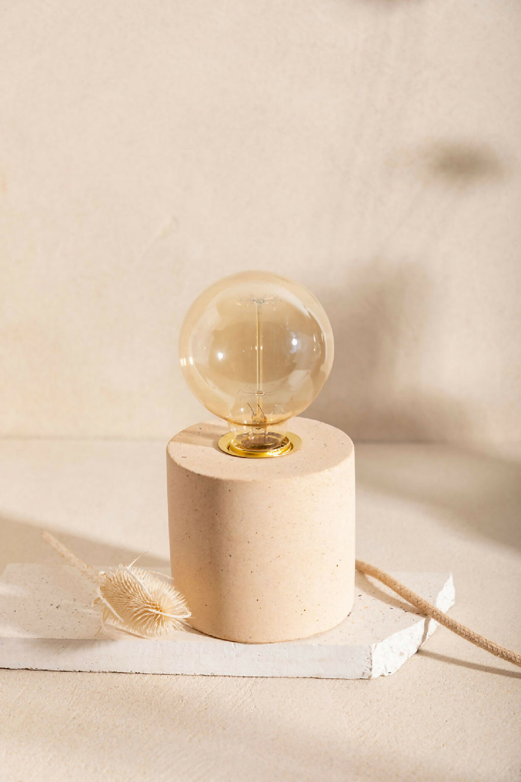 Lampe à poser à ampoule globe claire, base cylindrique blanche texturée, finition laiton