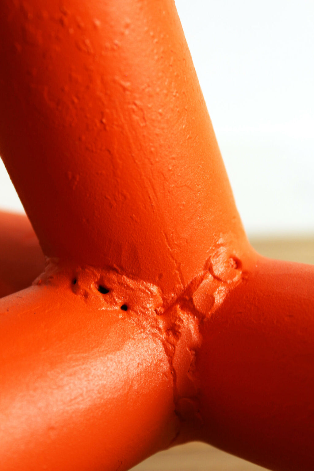 Lampe UMARELL Enrico orange : jonction du pied avec texture et relief du métal