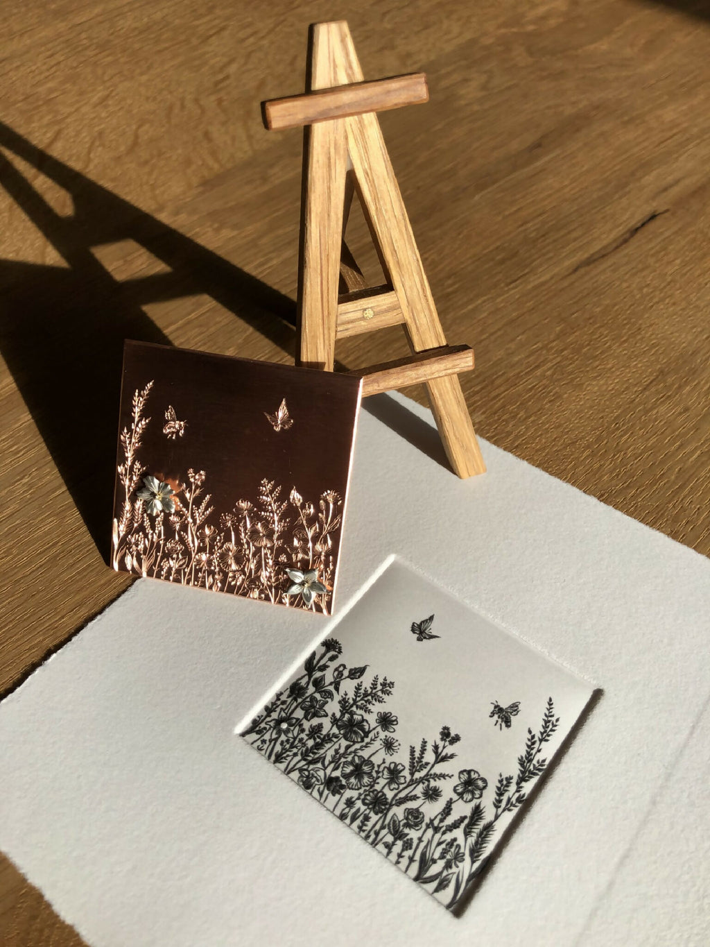 Tableau fleuri à cadre foncé et petite carte blanche, fleurs noires et papillons