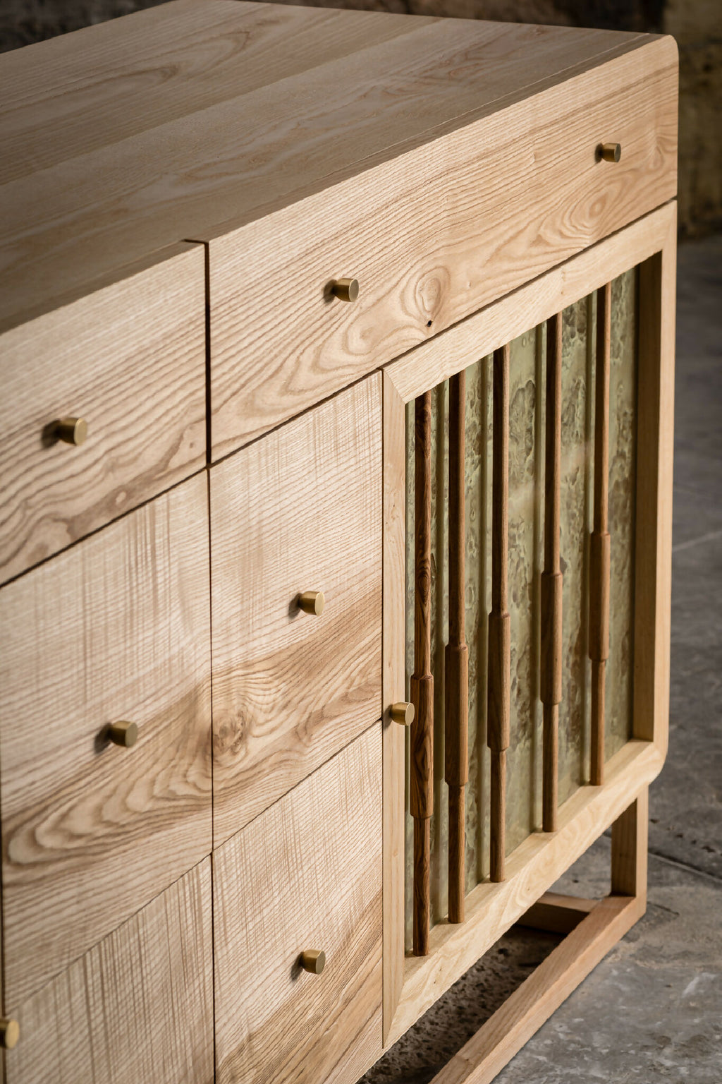Façade du buffet en bois clair : tiroirs et portes à lames verticales
