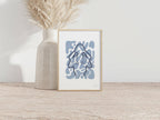 Tirage d’art A4 encadré, motif abstrait bleu, posé sur table en bois.