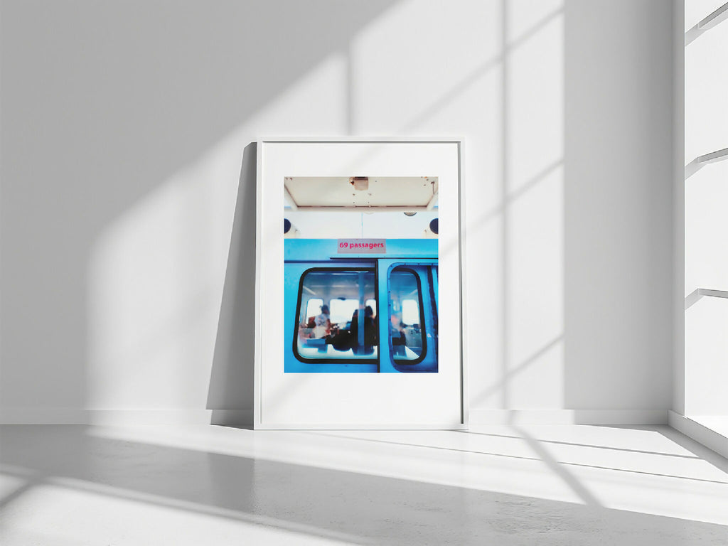 Photo encadrée rectangulaire, sur sol clair, vue intérieure de bus bleu
