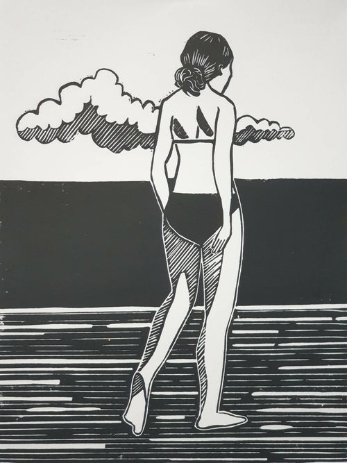 Affiche noir et blanc encadrée, femme debout jouant de la guitare sous des nuages.