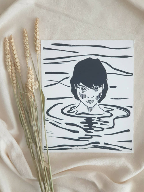 Impression noir et blanc sur papier blanc : visage stylisé et eau en lignes