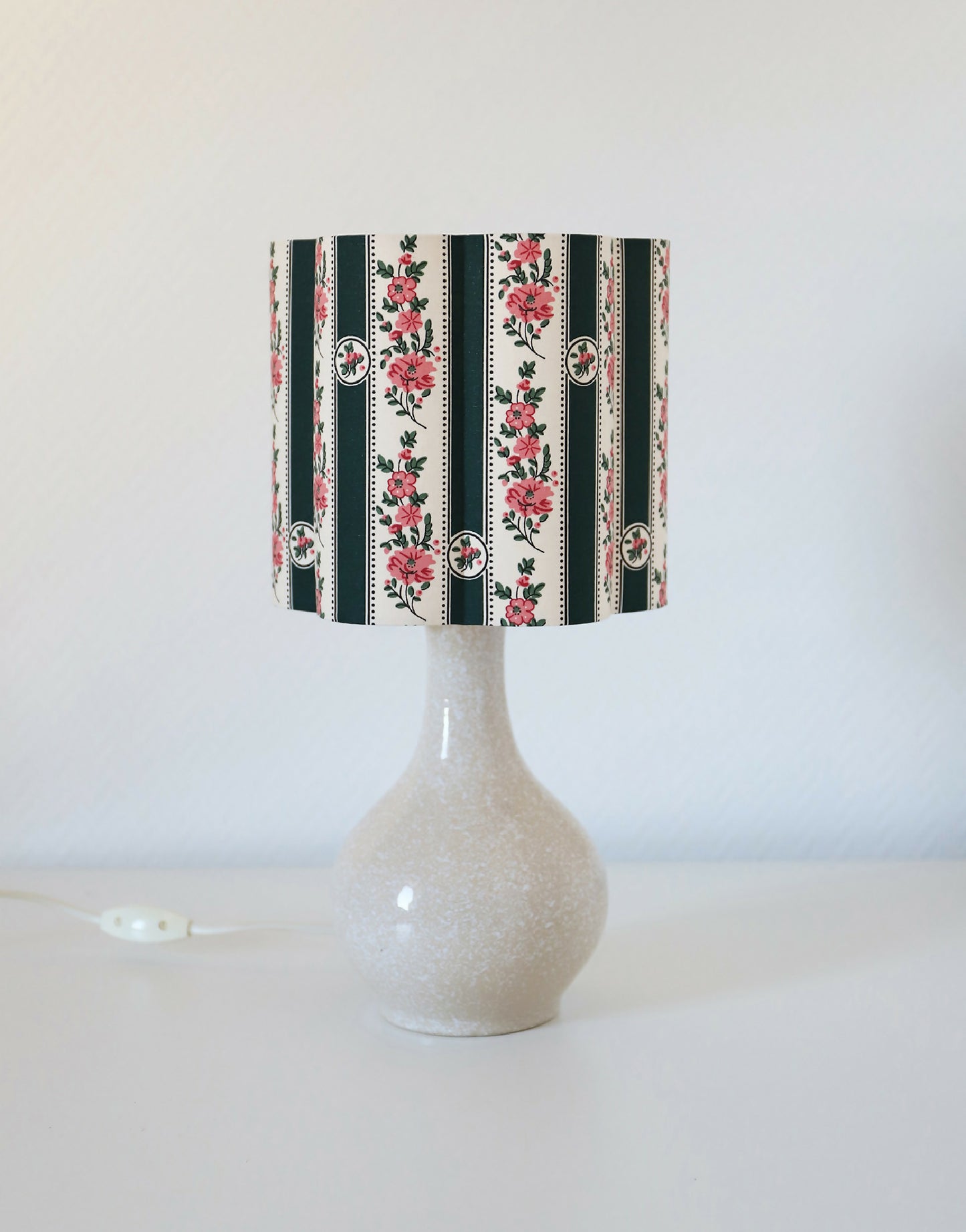 Abat-jour forme fleur Flora vert avec intérieur blanc, rayures et fleurs roses.